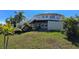 Lawn view of this home with two levels, stairs, and plenty of native landscaping at 19170 Aviation Ct, Port Charlotte, FL 33948