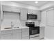 Close up kitchen with stainless steel appliances, and modern gray cabinets at 19505 Quesada Ave # Ss102, Port Charlotte, FL 33948