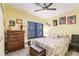 Cozy bedroom featuring yellow walls, ceiling fan, and ample natural light at 2040 Willow Hammock Cir # 208, Punta Gorda, FL 33983