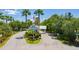 Community entrance featuring tropical landscaping, American flag and decorative signage at 2040 Willow Hammock Cir # 208, Punta Gorda, FL 33983