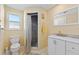 Bright bathroom featuring a walk in shower, toilet, sink and vanity with mirror at 21184 Edgewater Dr, Port Charlotte, FL 33952