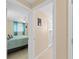 Hallway leading into bedroom with ceiling fan and blue curtains and door to bathroom at 21184 Edgewater Dr, Port Charlotte, FL 33952