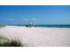 Idyllic beach scene with white sand, gentle waves, and relaxing beach umbrellas at 21422 Mallory Ave, Port Charlotte, FL 33952