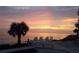 Peaceful beachfront scene with chairs facing the ocean under a colorful sky at 21422 Mallory Ave, Port Charlotte, FL 33952