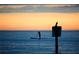 Scenic ocean view with a paddle boarder silhouetted against a vibrant sunset at 21422 Mallory Ave, Port Charlotte, FL 33952