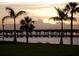 Scenic waterfront view featuring palm trees, a bridge and a peaceful sunset reflection on the water at 21422 Mallory Ave, Port Charlotte, FL 33952