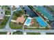 Aerial view of a beautiful waterfront estate featuring a pool, tennis court, and private dock at 240 Riviera Ct, Punta Gorda, FL 33950