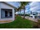 Lush backyard with green grass, palm trees, and a private boat dock at 240 Riviera Ct, Punta Gorda, FL 33950