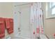 Well-lit bathroom featuring updated tile and shower head with a floral shower curtain at 240 Riviera Ct, Punta Gorda, FL 33950
