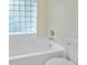 Bright white bathtub and toilet are adjacent to a glass block window in this bathroom at 240 Riviera Ct, Punta Gorda, FL 33950