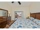 Cozy bedroom features a ceiling fan, dresser, and a sliding glass door leading to an outdoor view at 240 Riviera Ct, Punta Gorda, FL 33950