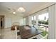 Cozy dining area with large windows overlooking the water, a stylish table, and a ceiling fan at 240 Riviera Ct, Punta Gorda, FL 33950