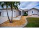 Charming home entrance featuring decorative door, rock landscaping, and a well-manicured lawn at 240 Riviera Ct, Punta Gorda, FL 33950