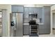 Stylish kitchen with gray cabinets, stainless steel refrigerator and oven, with easy access to the outdoors at 240 Riviera Ct, Punta Gorda, FL 33950