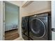 Efficient laundry room with modern, front-load washer and dryer and access to the bedroom at 240 Riviera Ct, Punta Gorda, FL 33950