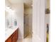 Bathroom featuring double sinks and a glass-enclosed tiled shower at 2419 Daisy Dr, North Port, FL 34289