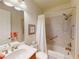 Bathroom features a tub with shower, vanity, and neutral tiles at 2419 Daisy Dr, North Port, FL 34289