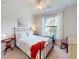 Bedroom with a large window, ceiling fan, and charming coastal decor at 2419 Daisy Dr, North Port, FL 34289