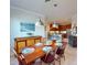Bright dining room open to the kitchen with a wooden table set for six under modern pendant lighting at 2419 Daisy Dr, North Port, FL 34289