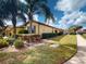 Well-maintained home featuring a lush lawn, mature landscaping, and charming architectural details at 2419 Daisy Dr, North Port, FL 34289