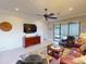 Stylish living room with ceiling fan, neutral paint, dark wood accents, and a view of the screened lanai at 2419 Daisy Dr, North Port, FL 34289
