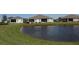 Scenic backyard view of residences overlooking a serene pond with lush green surroundings on a bright day at 24313 Westgate Blvd, Punta Gorda, FL 33980