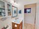 Bright bathroom featuring decorative lights and a vanity with wood cabinets and a framed mirror at 24313 Westgate Blvd, Punta Gorda, FL 33980