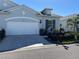 Charming home exterior featuring a two-car garage, well-manicured landscaping, and a neatly paved driveway at 24313 Westgate Blvd, Punta Gorda, FL 33980