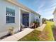 Inviting front entrance with a decorative wreath on the blue door and colorful flower arrangements at 24313 Westgate Blvd, Punta Gorda, FL 33980
