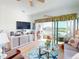 Cozy living room with stylish furniture, a large TV, and a view of the outdoor patio and lake at 24313 Westgate Blvd, Punta Gorda, FL 33980