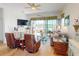 Cozy living room featuring hardwood floors, comfortable seating, and a scenic view of the pond and patio at 24313 Westgate Blvd, Punta Gorda, FL 33980