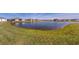 Scenic backyard view of residences overlooking a serene pond with lush green surroundings on a bright day at 24313 Westgate Blvd, Punta Gorda, FL 33980