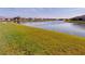 Picturesque view of a tranquil pond surrounded by manicured green lawns in a residential community on a clear day at 24313 Westgate Blvd, Punta Gorda, FL 33980