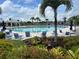Community pool with plenty of lounge chairs and umbrellas surrounded by lush landscaping and palm trees at 24313 Westgate Blvd, Punta Gorda, FL 33980