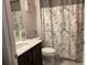 Functional bathroom featuring a vanity with a marble countertop and a shower with decorative leaf patterned curtain at 244 Surinam St, Punta Gorda, FL 33983