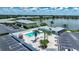 A high aerial view of the community pool, pool house, and parking area by the lake at 25225 Rampart Blvd # 1604, Punta Gorda, FL 33983