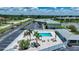 A high aerial view of the community pool, pool house, and parking area by the lake at 25225 Rampart Blvd # 1604, Punta Gorda, FL 33983