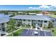 Aerial view of a two-story condo community with lake views, parking and green spaces at 25225 Rampart Blvd # 1604, Punta Gorda, FL 33983