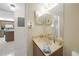 Cozy bathroom featuring a sink, counter space, a large mirror, and a glimpse of an adjacent kitchen at 25225 Rampart Blvd # 1604, Punta Gorda, FL 33983