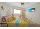 Inviting bedroom featuring beach-themed decor, a ceiling fan, and a window providing natural light at 25225 Rampart Blvd # 1604, Punta Gorda, FL 33983