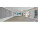 Large common area featuring plush carpets, a wall-mounted TV, and multiple ceiling fans at 25225 Rampart Blvd # 1604, Punta Gorda, FL 33983