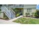Exterior view of a two-story condo with well maintained landscaping and white staircase at 25225 Rampart Blvd # 1604, Punta Gorda, FL 33983