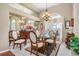 Elegant dining room features a glass table, chandelier, high ceilings, and ample natural light from a large window at 26373 Madagascar, Punta Gorda, FL 33983