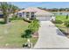 Charming single-story home features a tile roof, manicured lawn, and a long driveway leading to an attached two-car garage at 26373 Madagascar, Punta Gorda, FL 33983