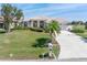 Well-manicured lawn and garden beds frame the front of this home with a concrete driveway and mailbox at 26373 Madagascar, Punta Gorda, FL 33983