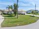 Beautifully landscaped front yard features lush green grass, mature trees, and well-maintained shrubbery at 26373 Madagascar, Punta Gorda, FL 33983