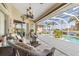 Inviting covered patio with wicker furniture, ceiling fan, and views of the screened pool and waterfront at 26373 Madagascar, Punta Gorda, FL 33983