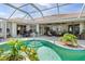 Screened pool with lush landscaping, offering a private and serene outdoor experience at 26373 Madagascar, Punta Gorda, FL 33983