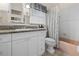 Bathroom with granite countertops, white cabinetry, and a bathtub with shower at 2720 Jay Pl, Sarasota, FL 34235