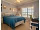 Comfortable bedroom with a large window, light blue walls and a ceiling fan at 3216 Purple Martin Dr # 121, Punta Gorda, FL 33950